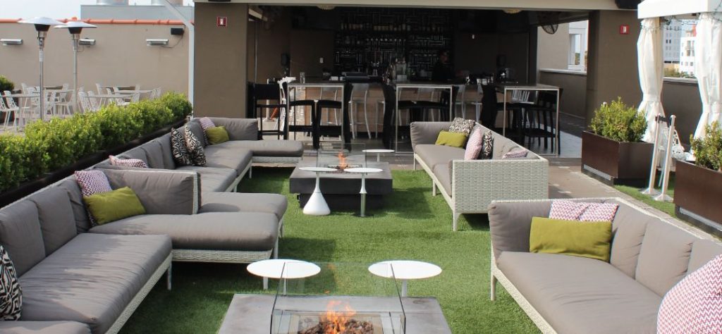 A rooftop bar that has artificial grass flooring.