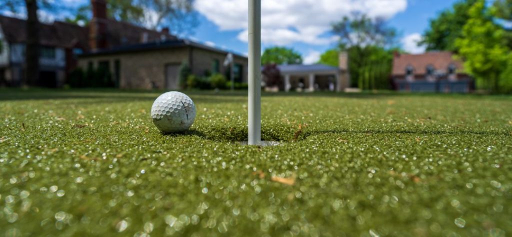 A close up of a golf driving range that has artificial turf