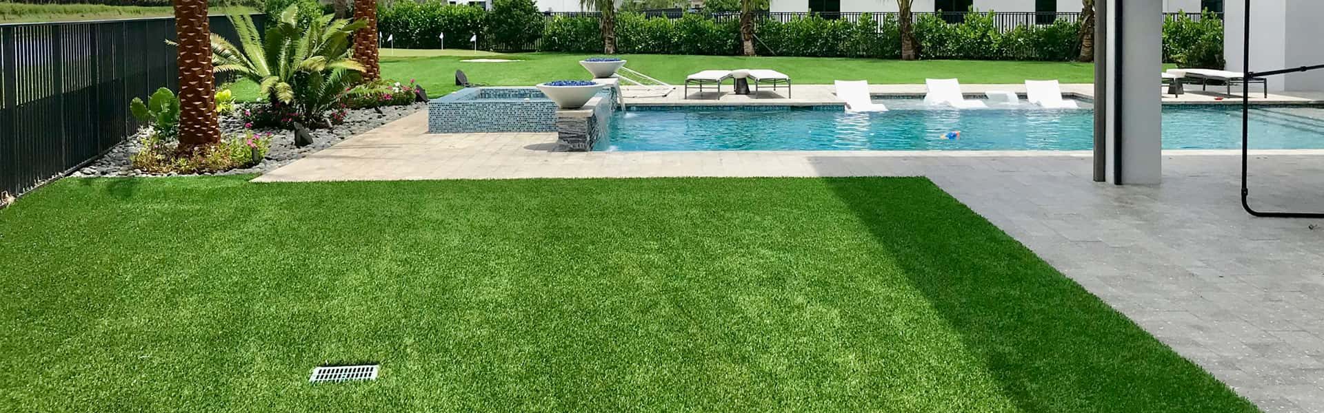 A Residence With Premium Artificial Grass Surrounding An Outdoor Pool And Patio Space