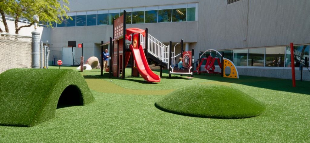 A playground landscaped with artificial turf.